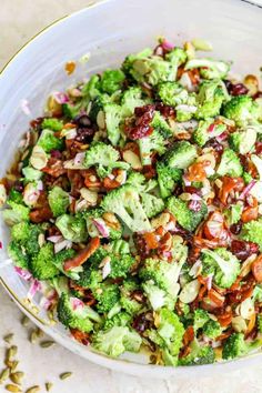 a white bowl filled with broccoli and other vegetables on top of a table