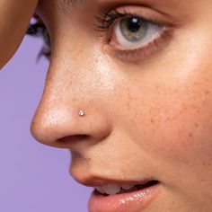 a close up of a woman's nose with a piercing on her left side