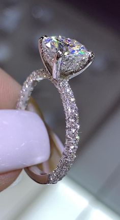 a close up of a person holding a diamond ring