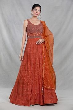 Rust orange sleeveless full length gown with Mughal bloom embroidery using thread, sequin, beads and cutdana highlights. Paired with a ditsy sequin floret work dupatta. - Aza Fashions Orange Maxi Gown For Wedding, Festive Orange Maxi Dress For Wedding, Fitted Orange Gown For Festive Occasions, Festive Orange Maxi Dress For Party, Designer Orange Dress With Mirror Work, Orange Sleeveless Dress For Festive Occasions, Orange Sleeveless Festive Dress, Festive Orange Maxi Dress, Traditional Orange Sleeveless Dress