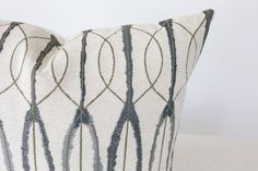 a white and blue decorative pillow sitting on top of a table