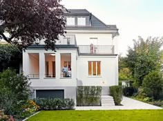 a large white house sitting on top of a lush green field