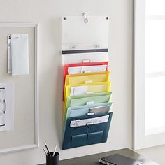 a wall mounted file organizer on the side of a desk