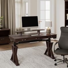 a computer desk with a monitor, keyboard and chair in front of a bookshelf