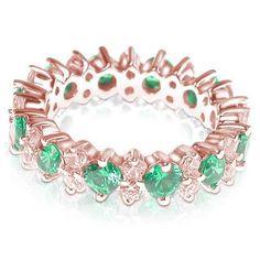 a rose gold ring with green stones