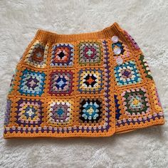 an orange crocheted skirt with multicolored squares on the front and bottom