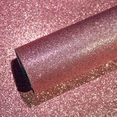 a roll of pink glitter paper laying on the ground