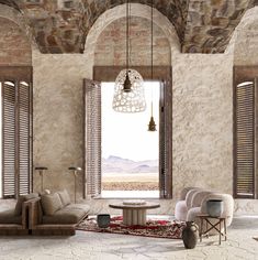 a living room filled with furniture next to two large windows and a stone wall covered in shutters