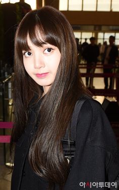 a woman with long brown hair standing in an airport