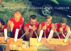 a group of people holding baseball bats in front of a green car with the words labor's international beer olympics written on it