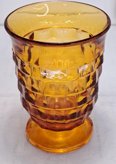 a yellow glass vase sitting on top of a table