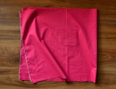 a pink cloth folded on top of a wooden table