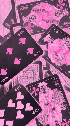 pink and black playing cards are laying on top of each other in the shape of hearts