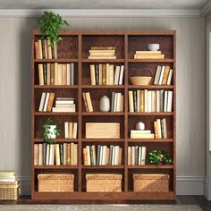 a bookshelf filled with lots of books next to a plant and wicker baskets