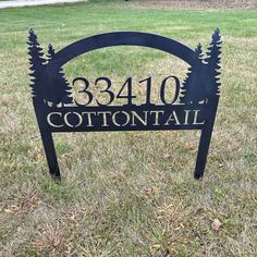 a sign that is in the grass with trees on it's back and says, 3240 cottontail