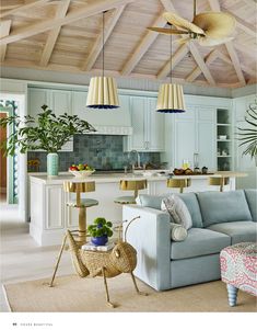 a living room filled with furniture next to a kitchen