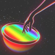 a hand reaching for something in a bowl that is multicolored with space and stars