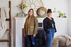 two women standing next to each other in front of a fireplace