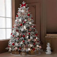 a white christmas tree with red and silver ornaments