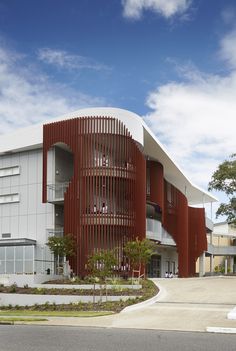 an architectural rendering of a building with red and white stripes on the front, along side a street