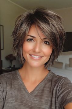 Click for More ➡️ | Save for Later ❤️  Ash brown highlights bring dimension to this chin-length bob, which features shaggy, uneven layers to create a lived-in look. This style is a great choice for those with a round face, as the layers help elongate the profile. (Chin-Length Shaggy Bob with Ash Brown Highlights - Short Shag Hairstyles) Chin Shaggy Bob, Choppy Bob Hairstyles For Round Faces, Shaggy Chin Length Bob Hairstyles, Short Shag Round Face, Best Hair Styles For Round Faces, Ear Length Hair With Layers, Shag Bob Hairstyles, Shaggy Layered Haircuts Medium, Choppy Layers With Bangs