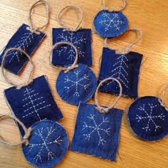 six pieces of blue fabric with white stitching on them, hanging from twine