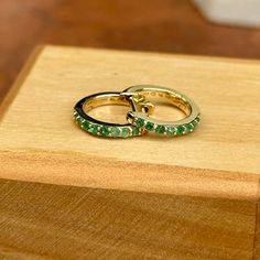 10KT yellow gold genuine emerald huggie hoop earrings. Emerald is the birthstone for May Babies! Length: 8mm Diameter: 8mm Thickness: 1.5mm Weight: 1.03 grams Stamped 10K 10K solid gold Latch backs One pair (16) 1.5mm genuine, prong set, round emeralds Can also do in ruby Green 14k Gold Hoop Earrings, Classic Gemstone Huggie Earrings For Gift, Stackable Huggie Earrings Fine Jewelry For Gift, Stackable 14k Gold Huggie Earrings For Anniversary, Stackable Huggie Earrings As Gift In Fine Jewelry, Classic Huggie Birthstone Jewelry, May Birthstone Huggie Earrings, Yellow Gold Emerald Huggie Jewelry, Yellow Gold Emerald Hoop Earrings For May Birthstone