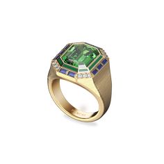 This opulent cocktail ring collection is a true statement of luxury and timeless elegance. Each piece showcases the exquisite craftsmanship of fine enamel work, featuring large, vibrant-colored gemstones paired with lab-grown diamonds. The classic trio of rich red, green, and blue hues come together in perfect harmony, evoking a sense of vintage sophistication. The textured gold band adds a layer of depth, enhancing the overall grandeur and ensuring these rings stand out as masterpieces of retro Luxury Emerald Ring With Gemstone Accents For Wedding, Luxury Octagon Ring With Gemstone Accents, Elegant Sapphire Gemstone Signet Ring, Elegant Sapphire Signet Ring With Gemstone, Elegant Sapphire Signet Ring, Modern Formal Emerald Jewelry, Luxury Emerald-cut Sapphire Ring With 17 Jewels, Luxury Oval Tsavorite Jewelry, Formal Yellow Gold Tsavorite Rings