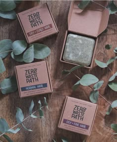 three boxes of zero waste bath sitting on top of a wooden table next to eucalyptus leaves