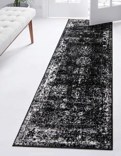 a black and white area rug in a living room with a bench on the side