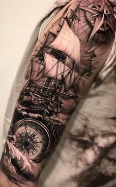 a man's arm with a ship and compass tattoo on it