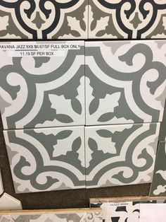 some tiles that are on the floor in a room with black and white designs around them