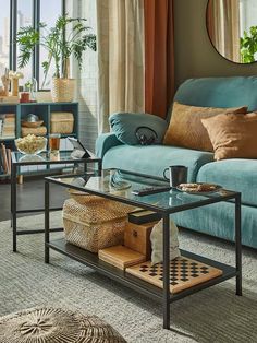 a living room filled with furniture and a mirror on top of the wall above it