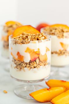 peaches and yogurt are garnished with granola in small glass dishes