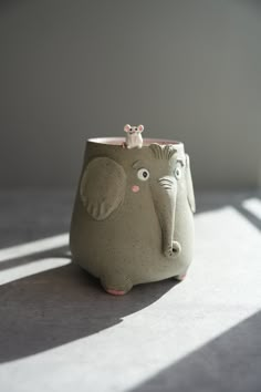 an elephant pot with a mouse on top