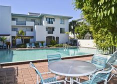 an apartment complex with a swimming pool and patio furniture