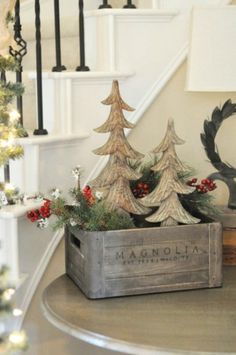 a christmas scene with pine trees in a wooden box on the table next to stairs