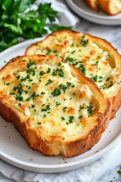 two pieces of bread with cheese and parsley on top sitting on a white plate