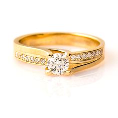 a yellow gold engagement ring with diamonds on it