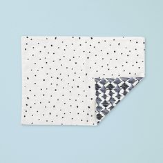 two napkins with black and white polka dots on them, one is folded in half