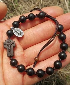 +. This is a Wooden Rosary Bracelet. +.It is knotted bracelet and it is adjustable . +.The crufix is carved in elevorate and three dementional shape. +.+.+.+.+. Materials +.+.+.+.+.+. Cross: Mpingo(Africa black wood) Beads : black wood +.+.+.+.+. Size +.+.+.+.+. Cross : 13.3mm(Width) *20mm(Height) Beads: 8mm +. Carved characters(e.g. baptismal name, name,etc) on back side +. please send me characters that you want. It's Free engraving +.Lead time is 3-7 business days. +.Delivery is currently bei Adjustable Wooden Beads Rosary Bracelet Gift, Adjustable Wooden Bead Rosary Bracelet Gift, Combat Rosary, Bible Jewelry, Mens Rosary, Rosary Making, Wooden Rosary, Cross Wood, Diy Bracelets With String