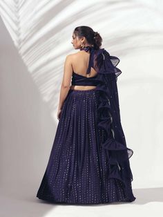 A three-piece Purple halter lehenga set from the Suruchi Parakh collection. This gorgeous georgette crepe lehenga is paired with a zardosi handwork satin blouse. The outfit is completed with a matching soft organza dupatta. The halter blouse has a feather neckline with a back tie-up. And, the dupatta has a beautiful touch of ruffle and zardozi handwork hemline. Evening Georgette Dresses With Cutdana, Evening Georgette Dresses With Cutdana Detail, Georgette Sets With Pallu For Evening, Evening Silk Lehenga With Mirror Work, Silk Lehenga With Mirror Work For Evening, Evening Semi-stitched Sets With Cutdana Details, Floor-length Satin Lehenga For Party, Semi-stitched Evening Sets With Cutdana Detail, Semi-stitched Cutdana Sets For Evening