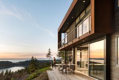 a person sitting at a table on top of a wooden deck next to a building