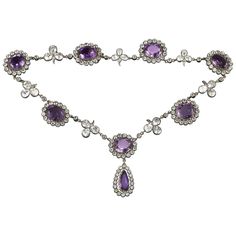 A late Victorian amethyst and rock crystal necklace, the seven oval-shaped amethysts surrounded by a cluster of round-cut rock crystal set in silver to yellow gold, each cluster separated with a rock crystal folitate trefoil, the centre cluster suspending a pear-shaped amethyst and rock crystal drop,the amethysts estimated to weigh 60 carats in total, mounted in gold and silver, circa 1880, measuring approximately 40 x 2.2cm, gross weight 62.5grams. A gorgeous and dramatic amethyst and crystal n Luxury Purple Round Necklace, Amethyst Oval Multi-stone Necklace, Oval Amethyst Multi-stone Necklaces, Oval Amethyst Multi-stone Necklace, Amethyst Rock, Rock Crystal Necklace, 1st Dibs, Purple Necklace, Gold Bar Necklace