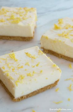 four pieces of cake sitting on top of a counter covered in frosting and yellow sprinkles