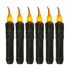 five lit candles in the shape of sticks with orange lights on them, set against a white background