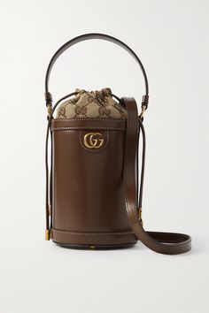 Gucci's beloved 'Ophidia' collection is defined by timeless silhouettes and signature details. Crafted in Italy from smooth leather, this bucket bag is embellished with the iconic gold-tone 'GG' hardware and lined with a monogrammed canvas-jacquard pouch that secures with drawstring ties. Carry yours by the top handle or shoulder strap. Luxury Leather Bucket Bag, Luxury Chic Satchel Baguette Bag, Luxury Trendy Baguette Bag For Party, Luxury Elegant Satchel With Single Shoulder Strap, Cheap Elegant Gold Baguette Bag, Luxury Baguette Bag With Metal Hardware Crossbody, Luxury Miu Miu Shoulder Bag For Daily Use, Luxury Chic Baguette Bag With Zipper Closure, Luxury Baguette Bag With Metal Hardware For Women