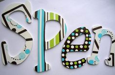 the letters are made out of wood and decorated with polka dot designs on white paper