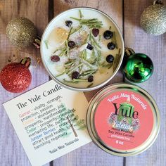 the yule candle is next to two tins of christmas decorations and a note