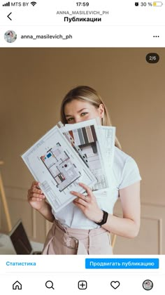 a woman is holding up some papers in front of her face